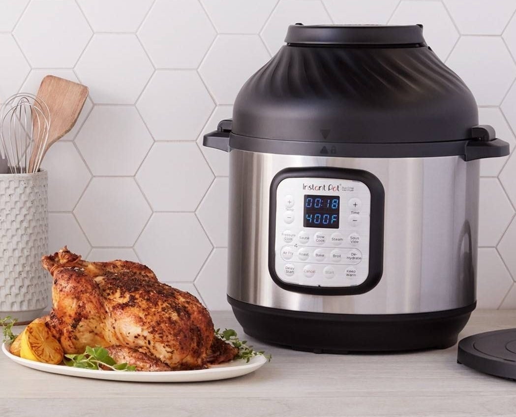 instant pot with a roasted chicken next to it