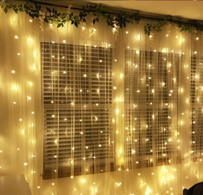 Fairy lights hanging over a sheer curtain 