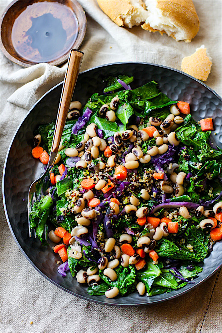a plate of greens, black-eyed peas, carrots, and cabbage