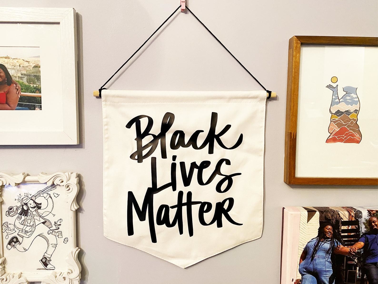 white wall hanging with the words "Black lives matter" written in black