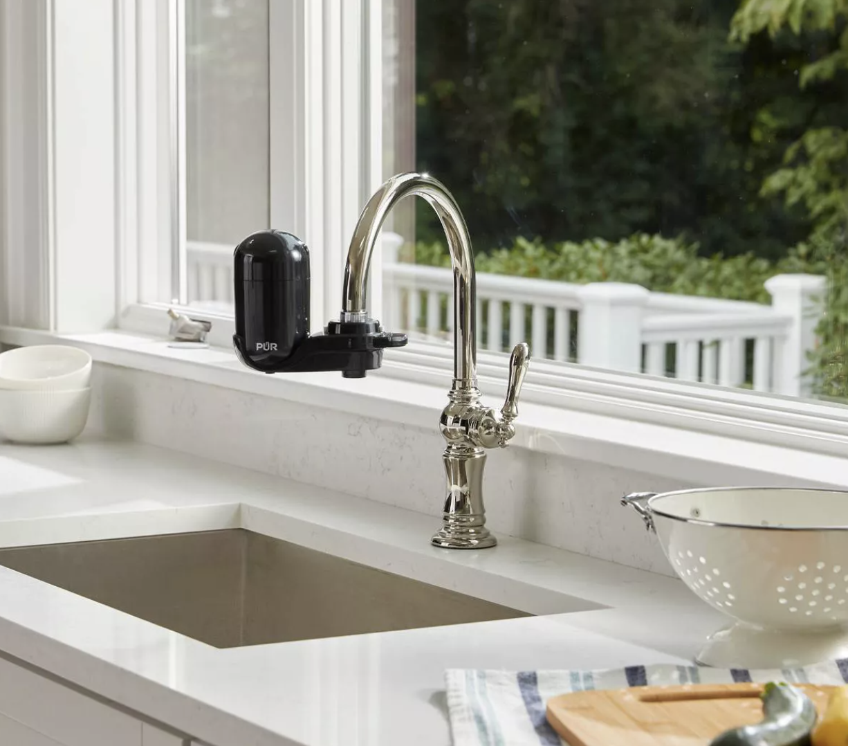 Black PUR water filtration system attached to silver sink faucet