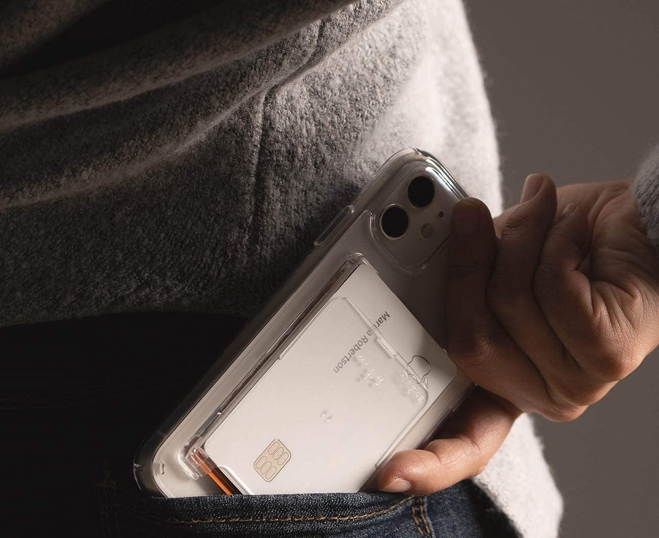 A person sliding their phone with the card slot into their back pocket