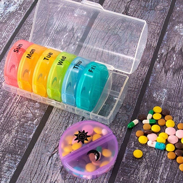 The weekly pill organizer with days of the week written on each container, as well as a sun and moon sticker to emphasize the divided sides of each container  