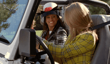 Cher and Dionne doing a special handshake in a Jeep