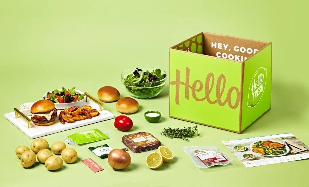 Box on green background next to vegetables, produce, fruit, and pamphlet