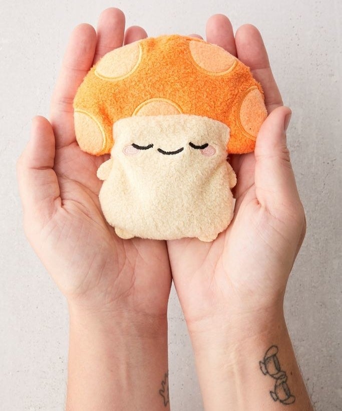 Mushroom shaped heating pad inside a person's palms