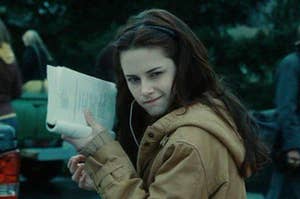Bella holding up a book that she's reading to signal that she's busy