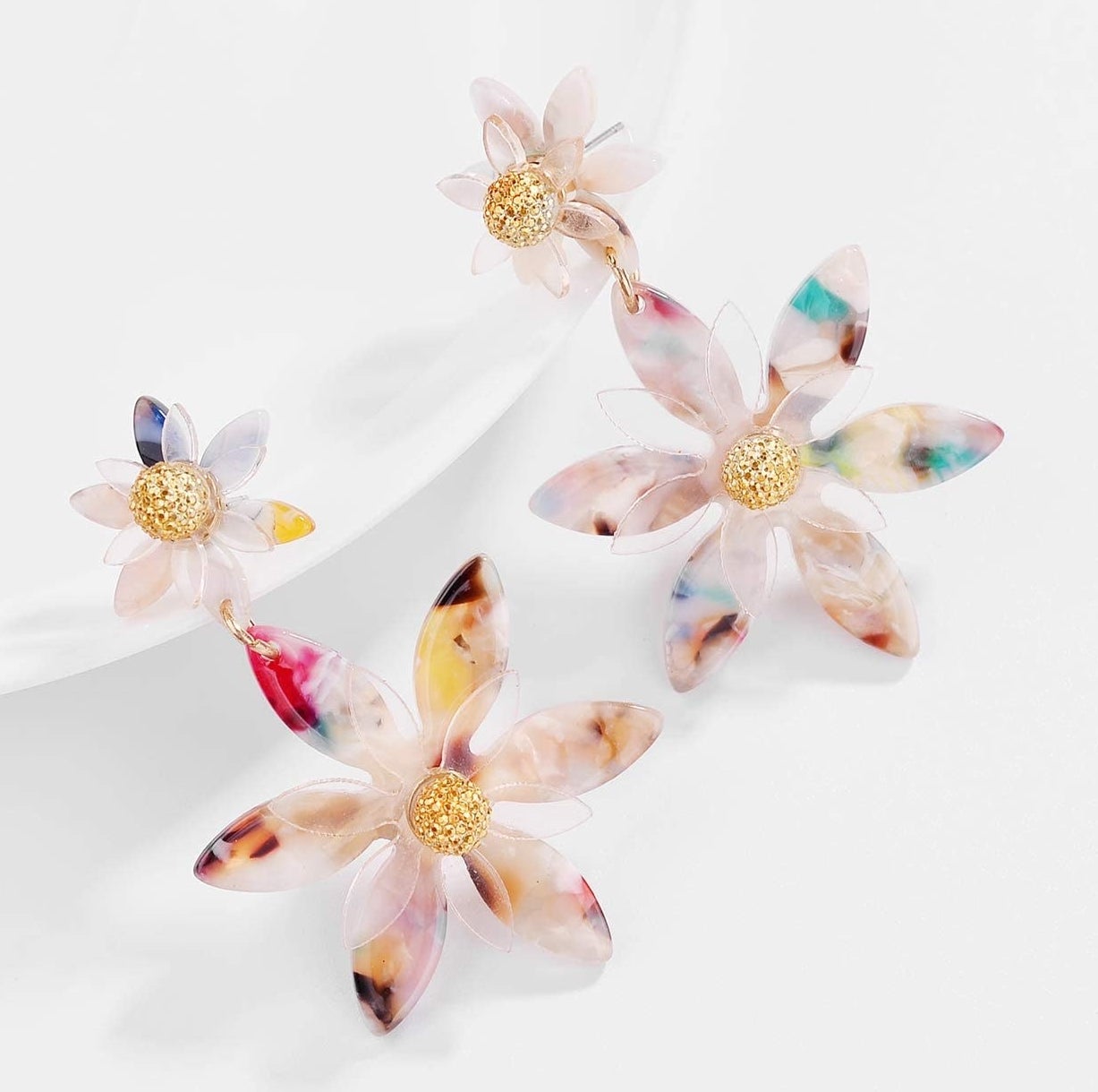 The multicolored drop earrings, each with a small and large flower with a gold center