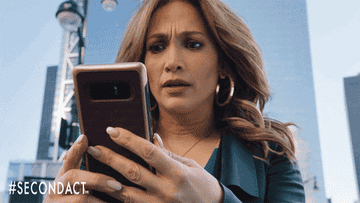 gif of jennifer lopez staring at a cell phone looking worried