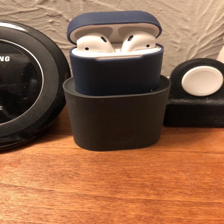 Reviewer photo of black silicone AirPods stand placed on desk with AirPods on top