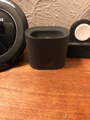 Reviewer photo of black silicone AirPods stand placed on desk