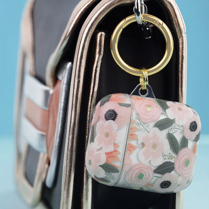 Floral Rifle Paper Co AirPods case clipped onto small clutch