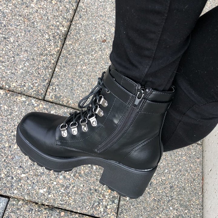 A reviewer wearing the boots in black