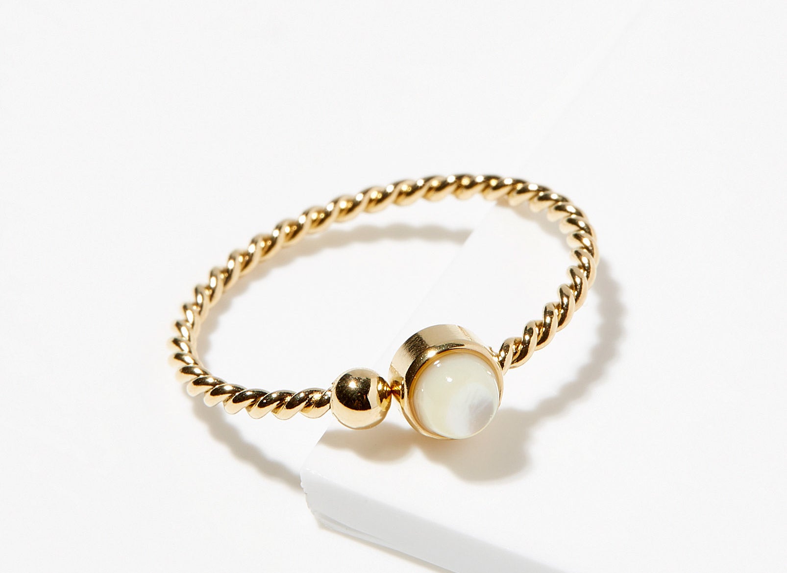 A small gold ring with a pearl jewel at the center