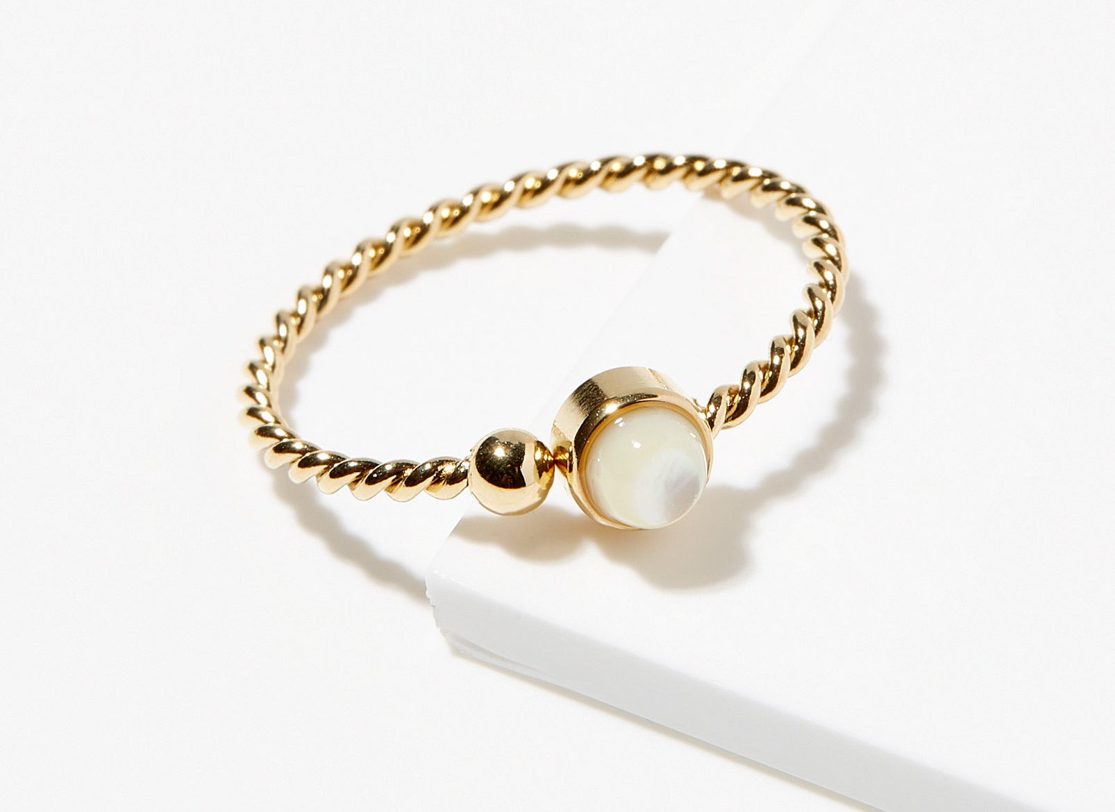 A small gold ring with a pearl jewel at the center