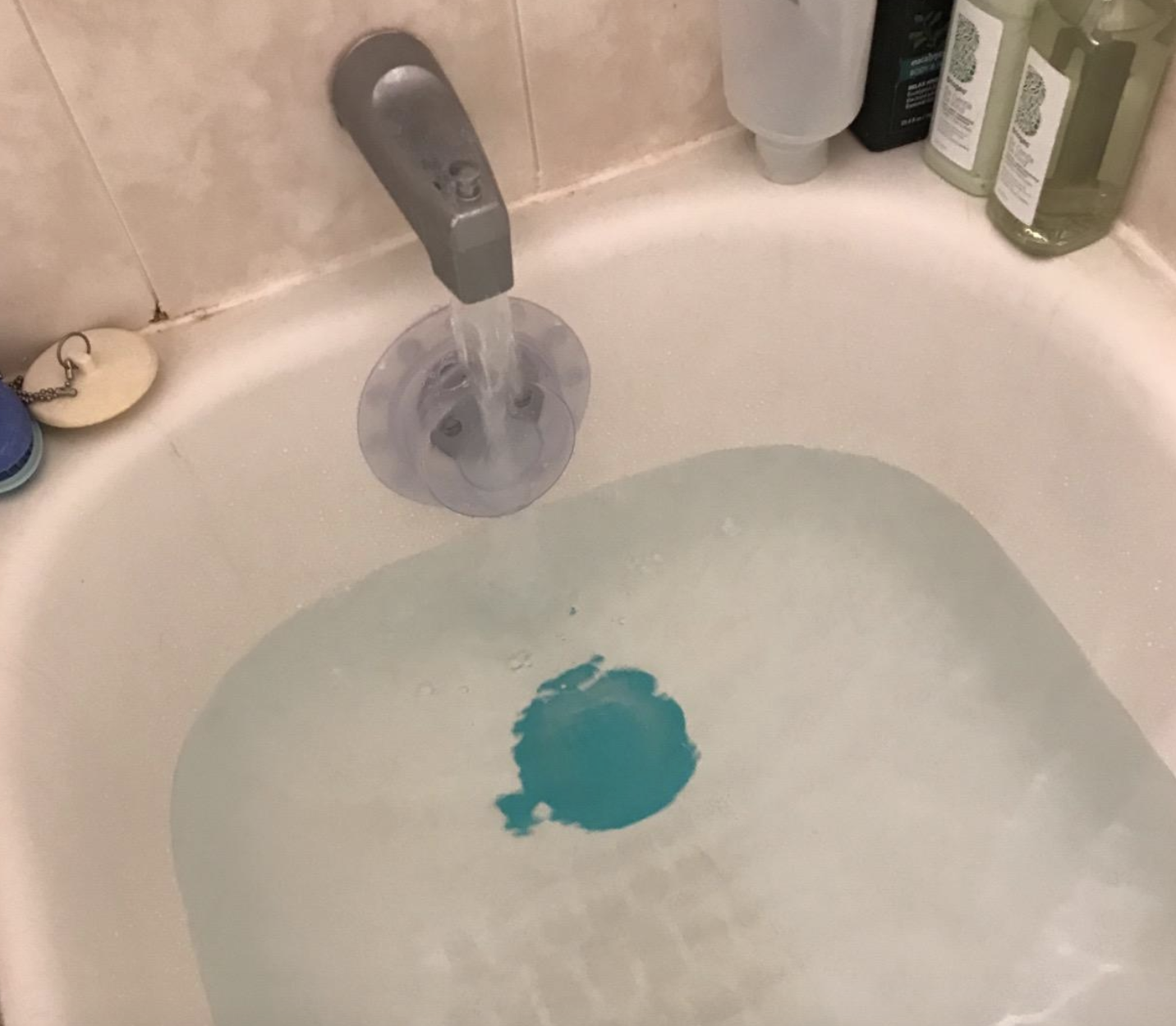 reviewer photo of the blue tub stopper in bath full of water