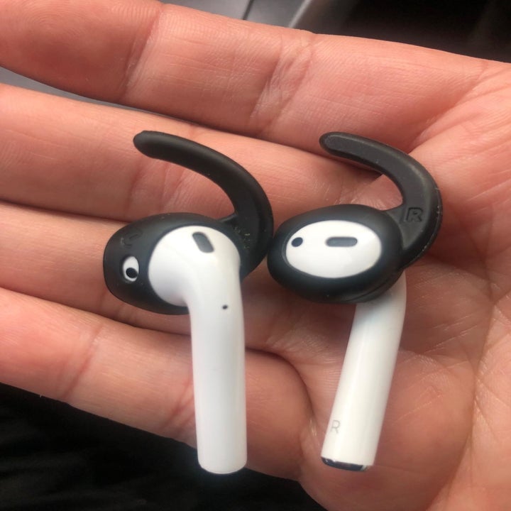 Amazon reviewer holding AirPods with silicone grips