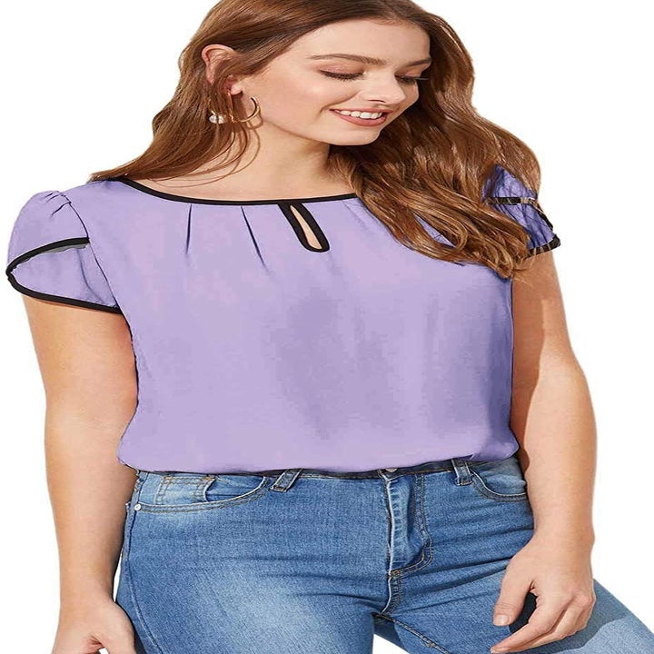A model wearing the tulip-sleeve top in lavender with black piping