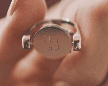 a gif of the silver ring with a base plate spinning to reveal that it says &quot;let go&quot;