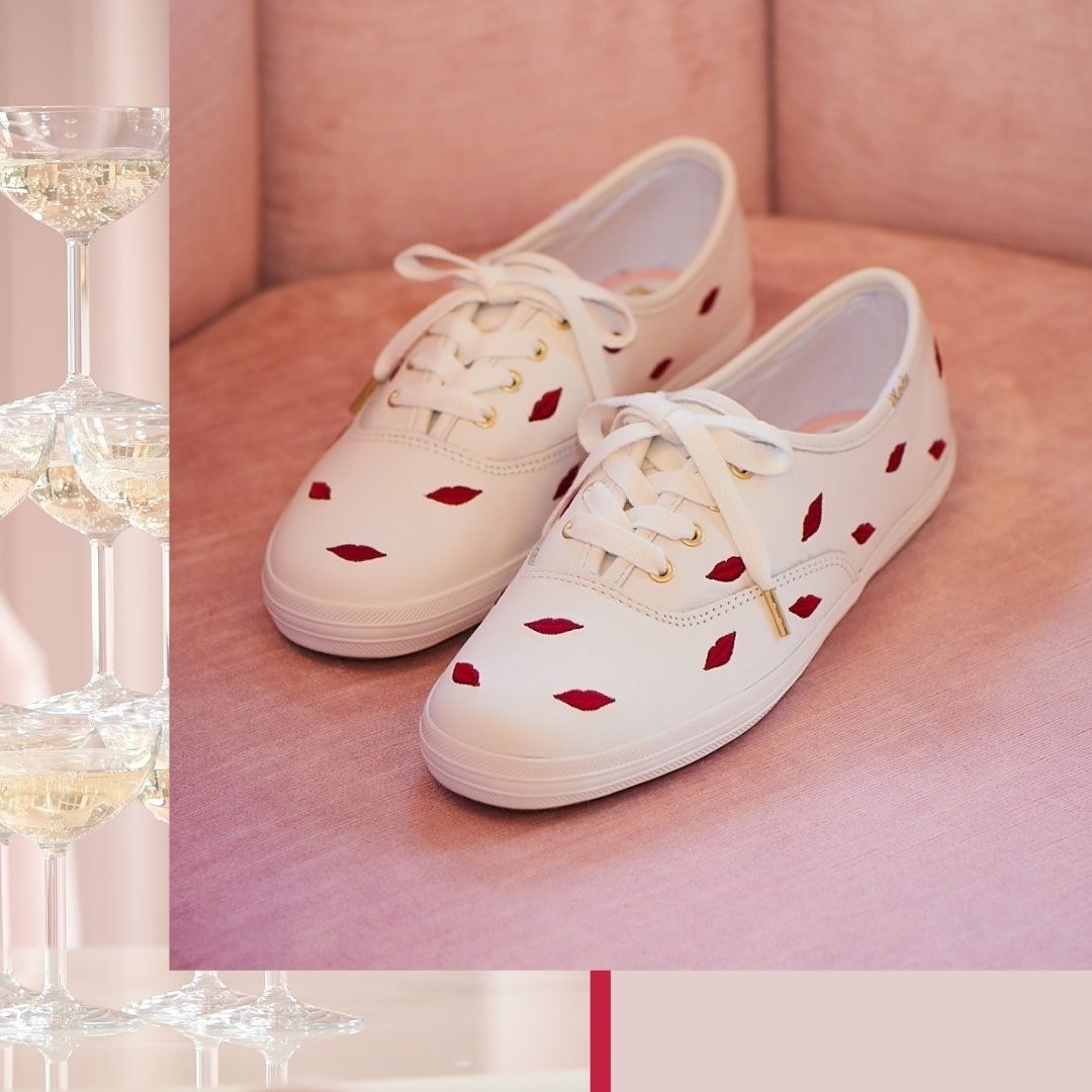 A pair of tennis shoes with embroidered lips all over the top and sides