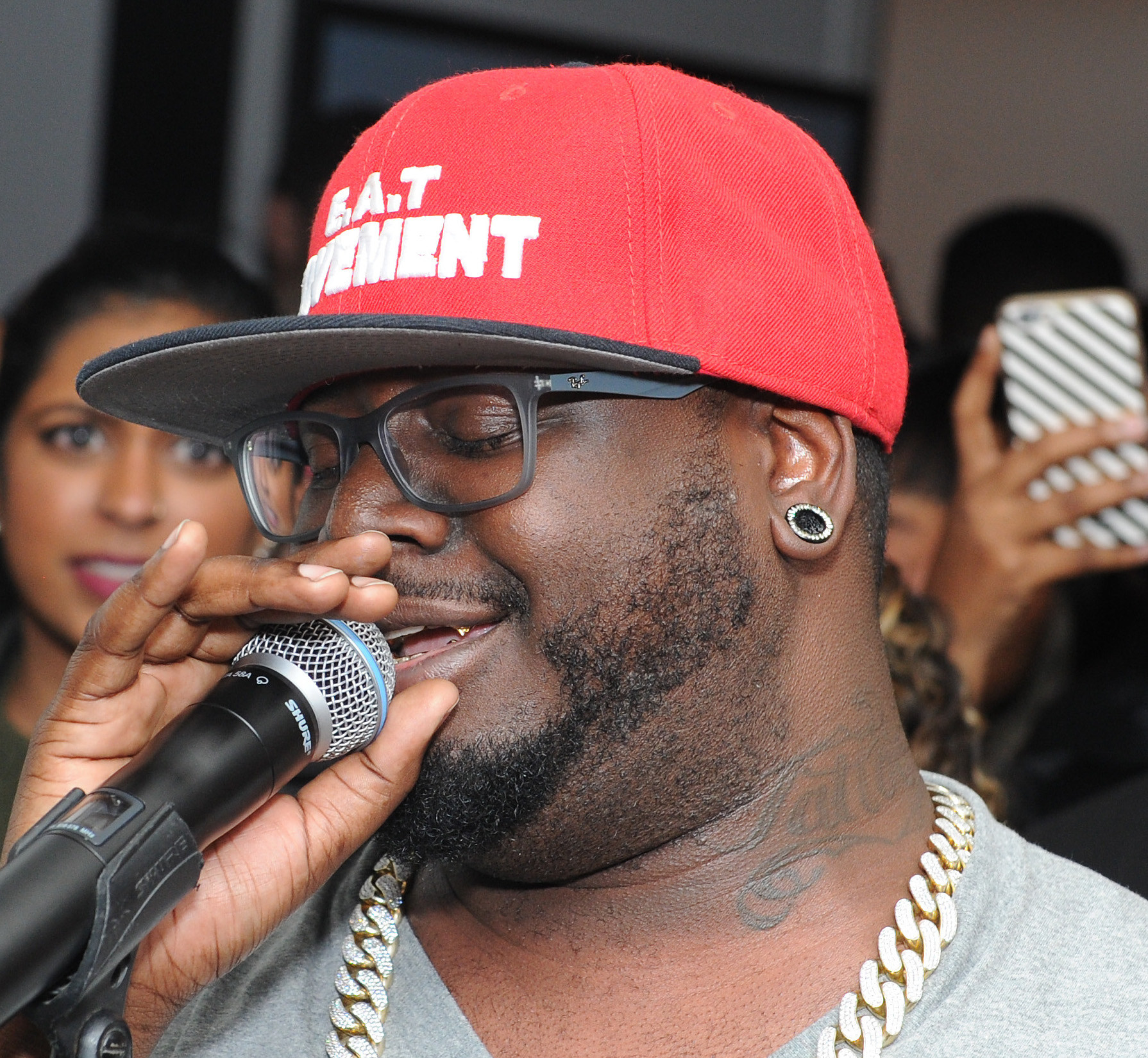 T-Pain with a microphone and showing his &quot;Tattoo&quot; tat