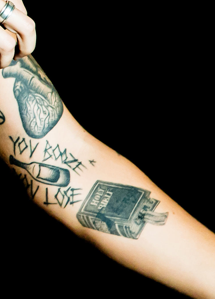 A tat of the &quot;Holy Bible&quot; along with other tats on his arm