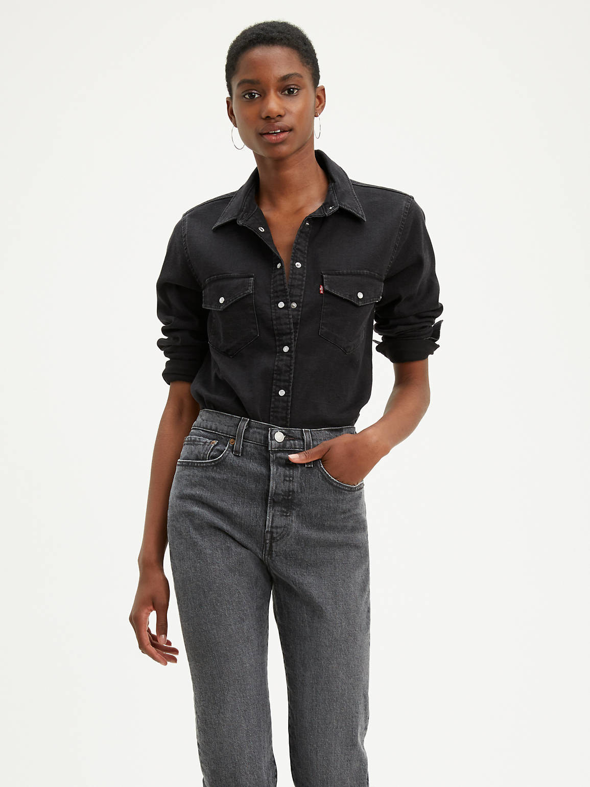 a model wearing the shirt in black with a pair of dark-colored jeans 