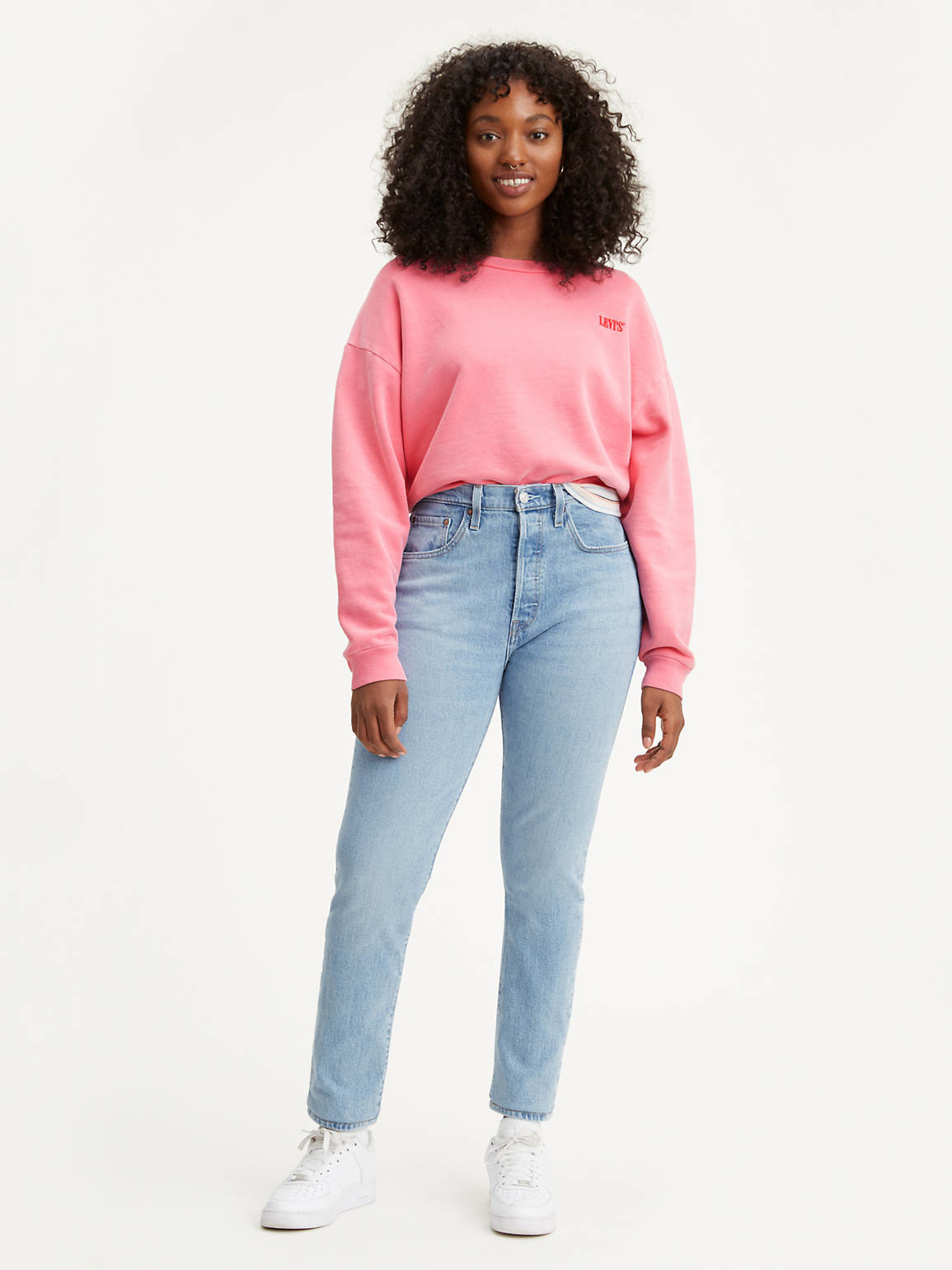 a model wearing the light-wash straight jeans with a pink sweater