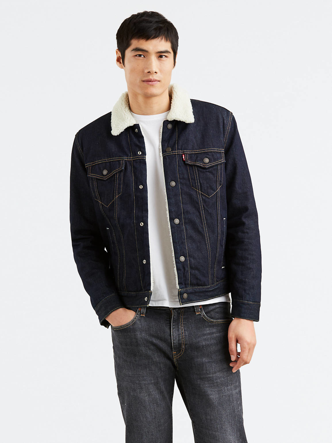 a model wearing the sherpa=lined jacket in dark wash