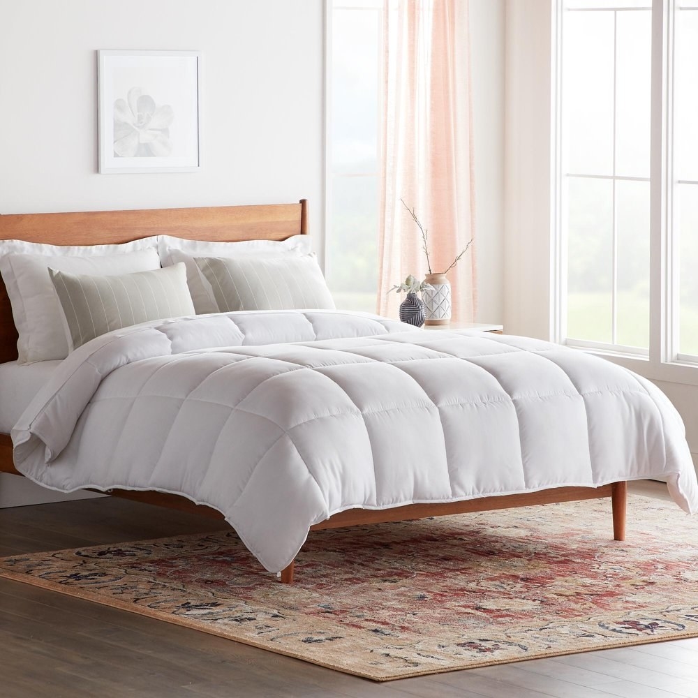 a white duvet with a square pattern stitched throughout on a bed