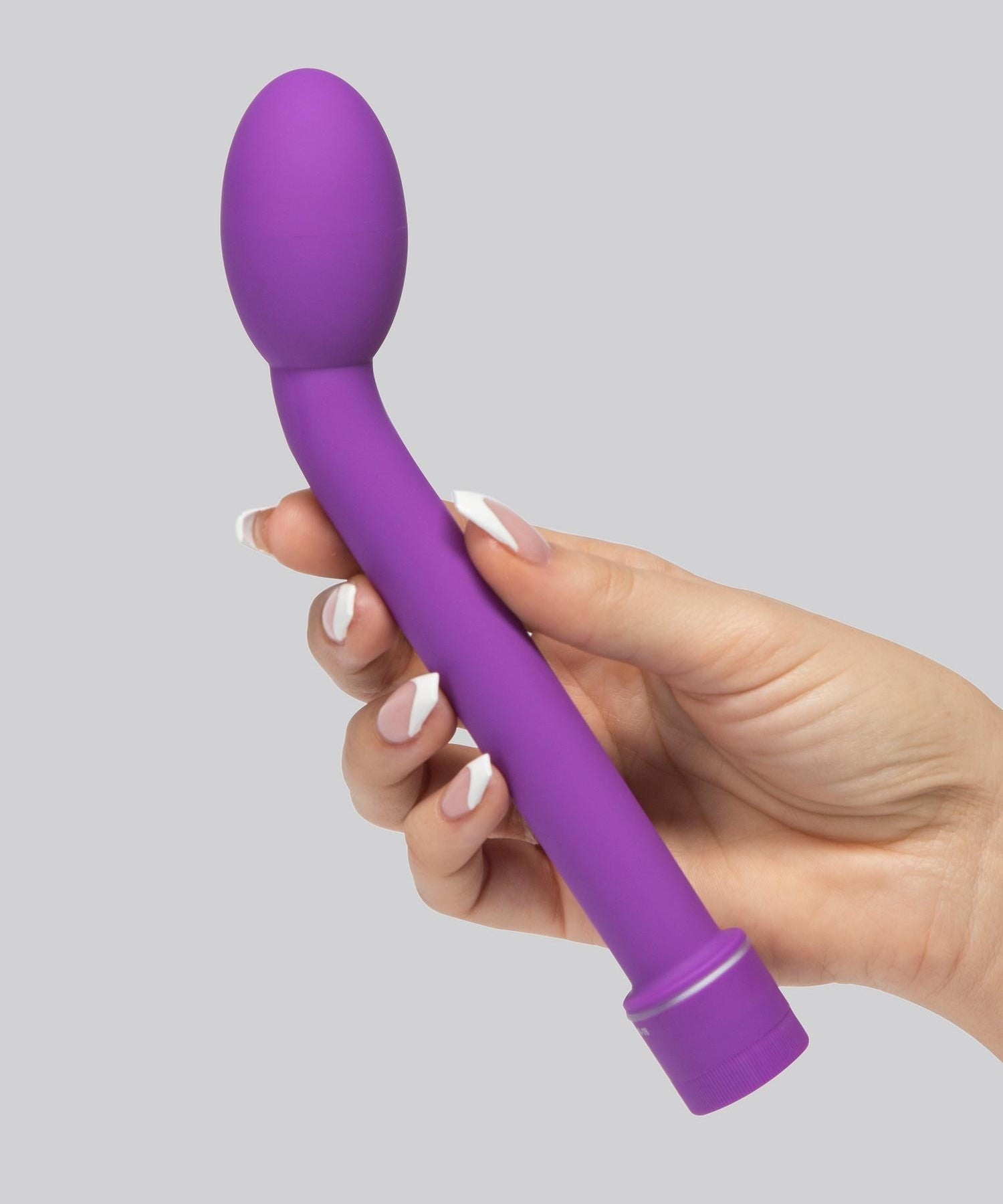 A hand holding the purple curved wand with bulbous tip