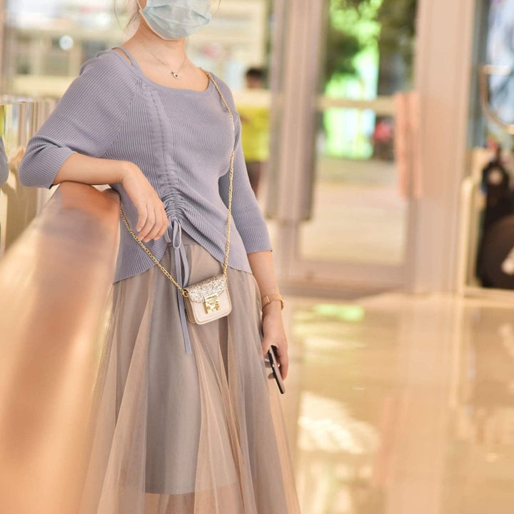 Model wearing silver crossbody AirPods case