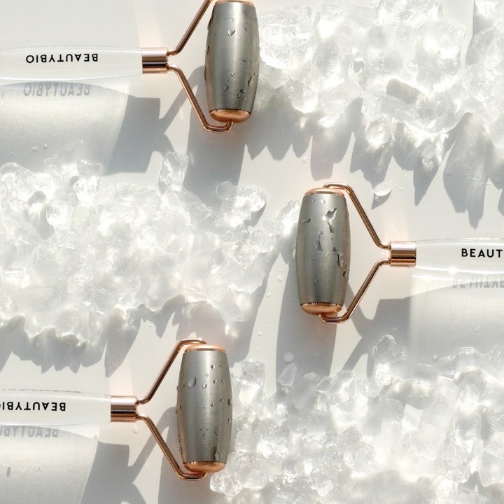 A trio of stainless steel rollers arranged around some crushed ice