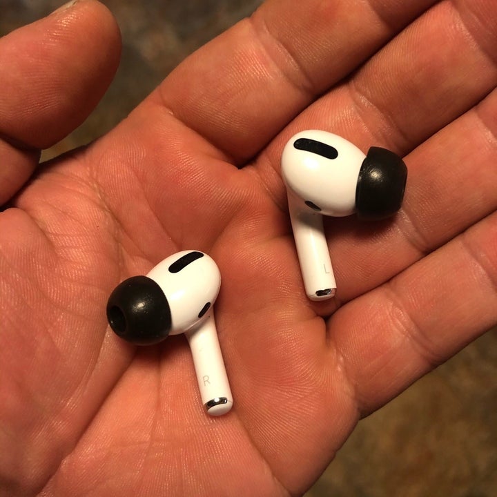 Amazon reviewer holding AirPods Pro with memory foam tips installed