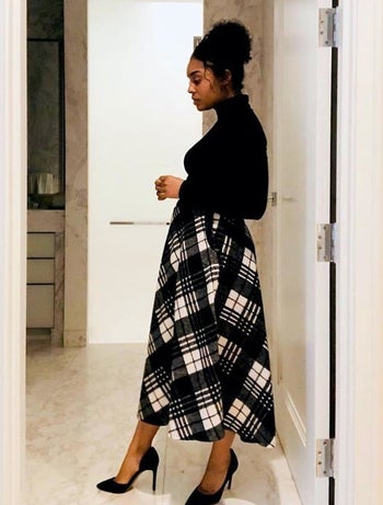 Another reviewer wearing black and white skirt showing it from the side