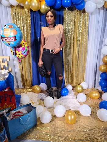 reviewer wearing the sleevless padded tee in light orange