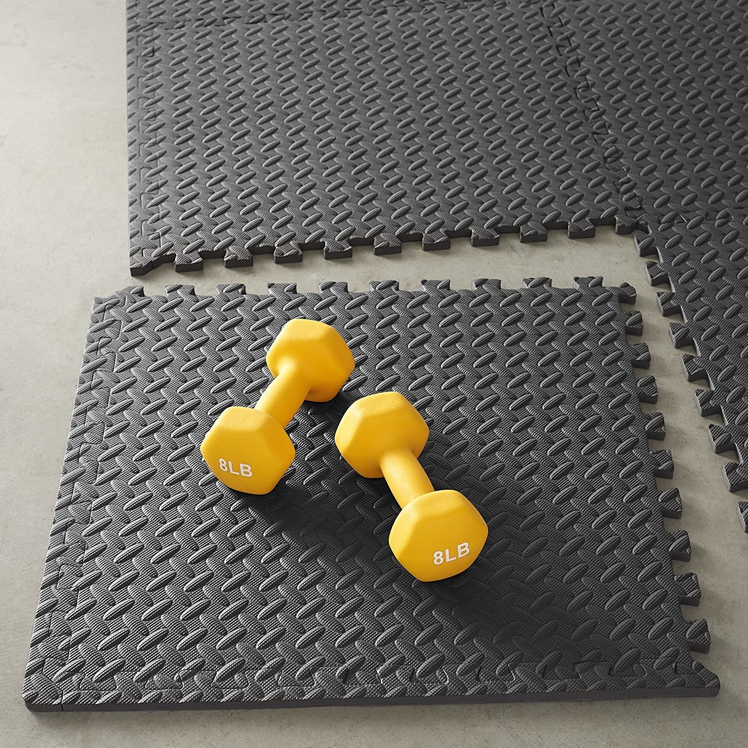 Interlocking foam tiles with a pair of 8 pound weights sitting on one