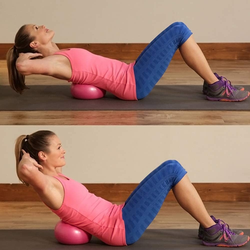 A person using the pilates ball to assist a crunch