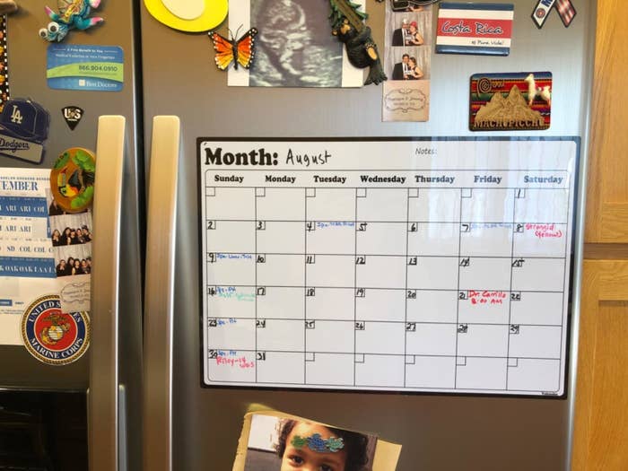 reviewer photo showing the calendar on their fridge surrounded by photos and magnets