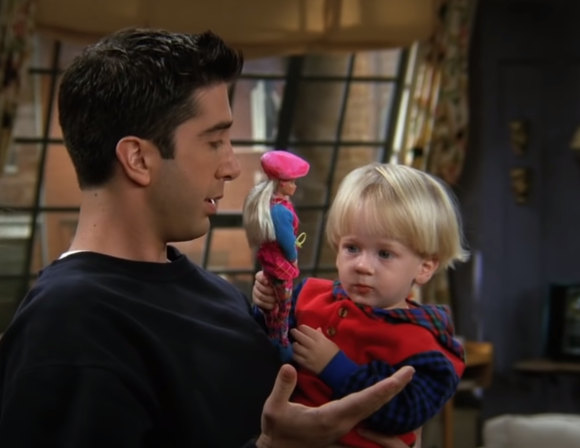 Ross holding his son Ben while Ben plays with a Barbie on &quot;Friends&quot;