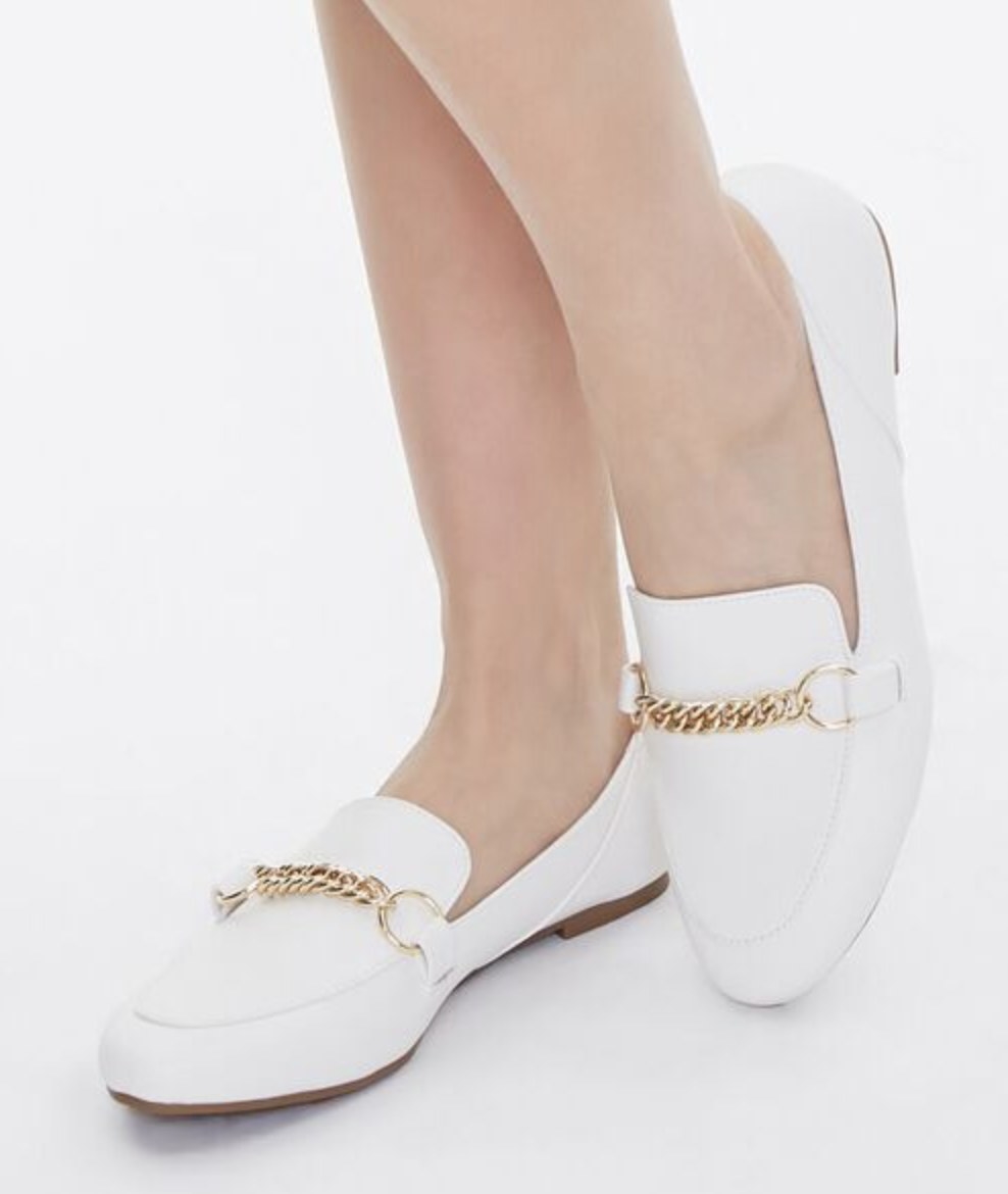 Model is wearing white leather loafers