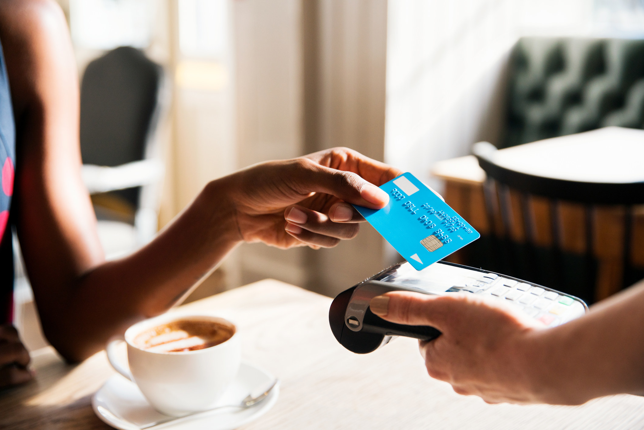 Model using a credit card to purchase coffee