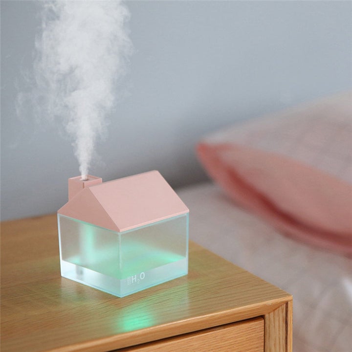 A humidifier / diffuser with a pink roof and green light