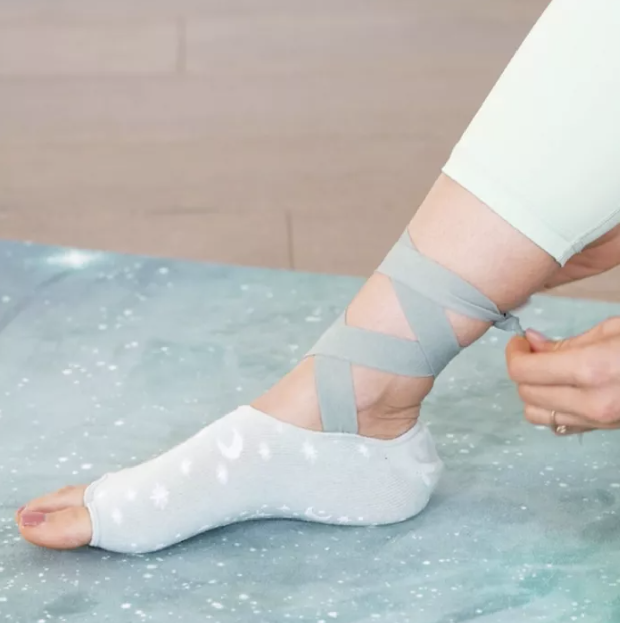 Model wears light blue lace-up grip socks with a moon and star design