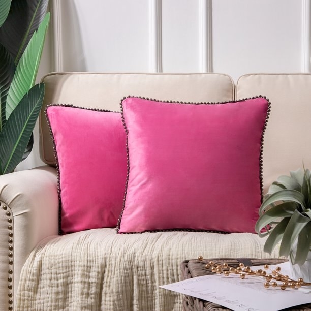 The pillows in pink, which are square and have some thin dark trim around the edges