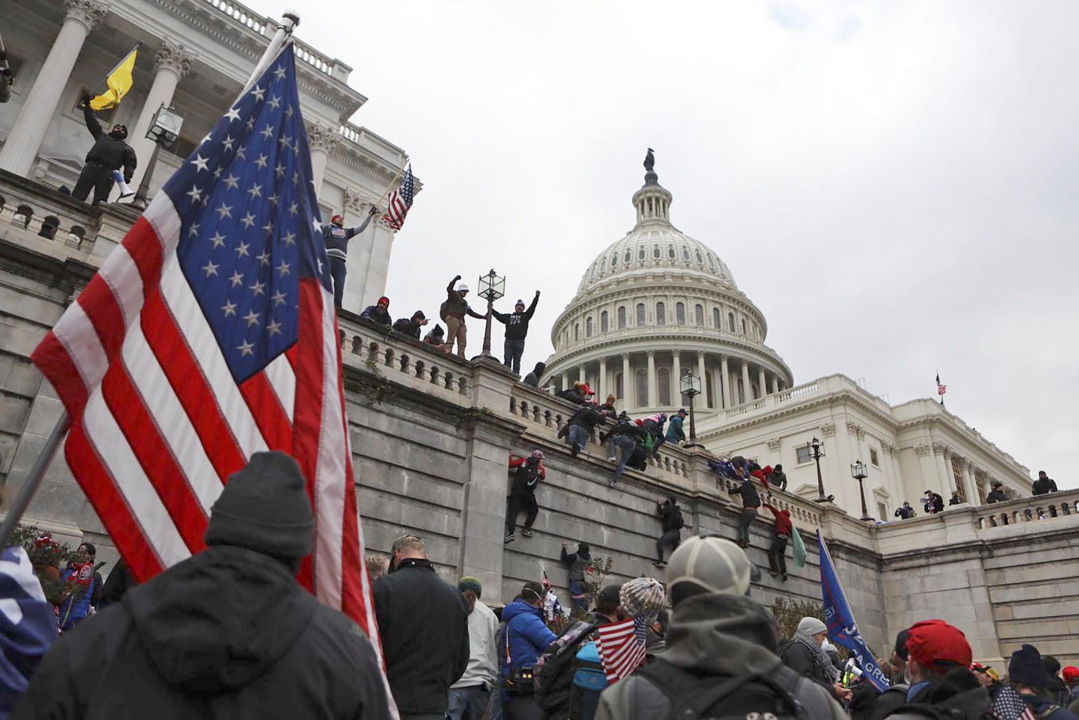 People scale the walls outside the Capitol building in DC