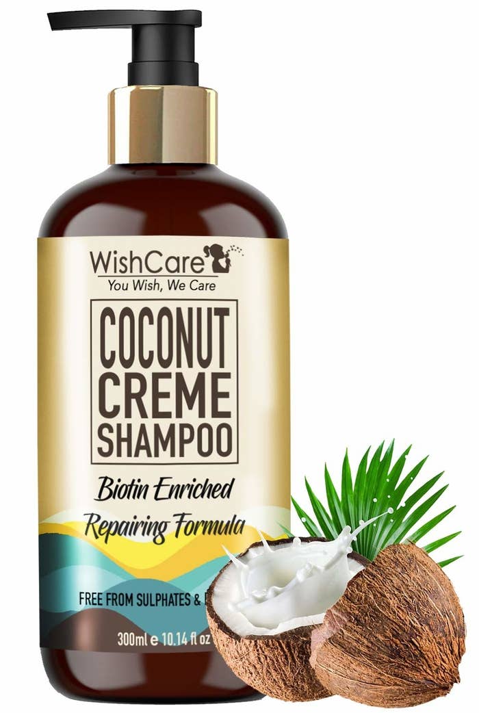 Packaging of the coconut creme shampoo next to coconuts