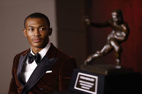 DeVonta Smith staring at Heisman Trophy.