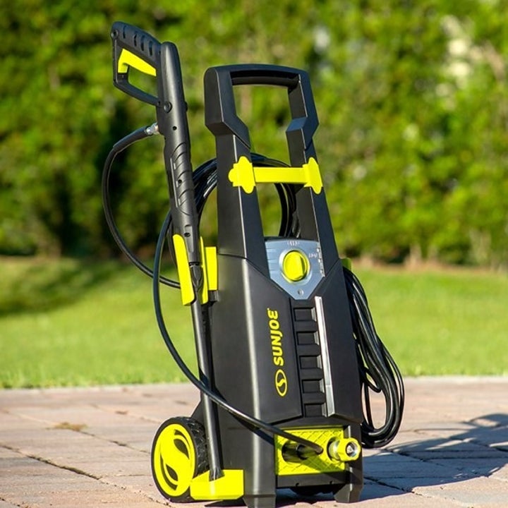 black sun joe power washer with neon yellow accents outside 