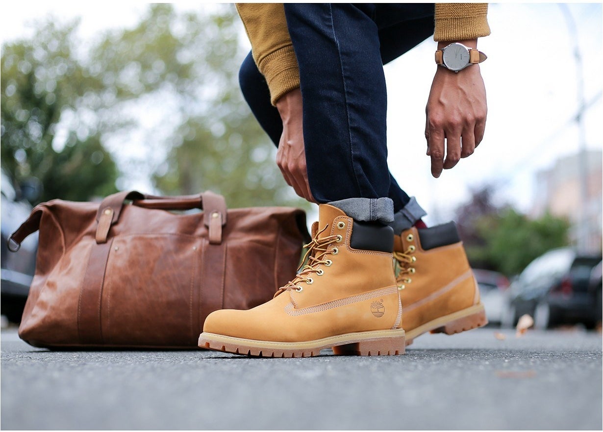 Model wearing a pair of Timberlands in wheat